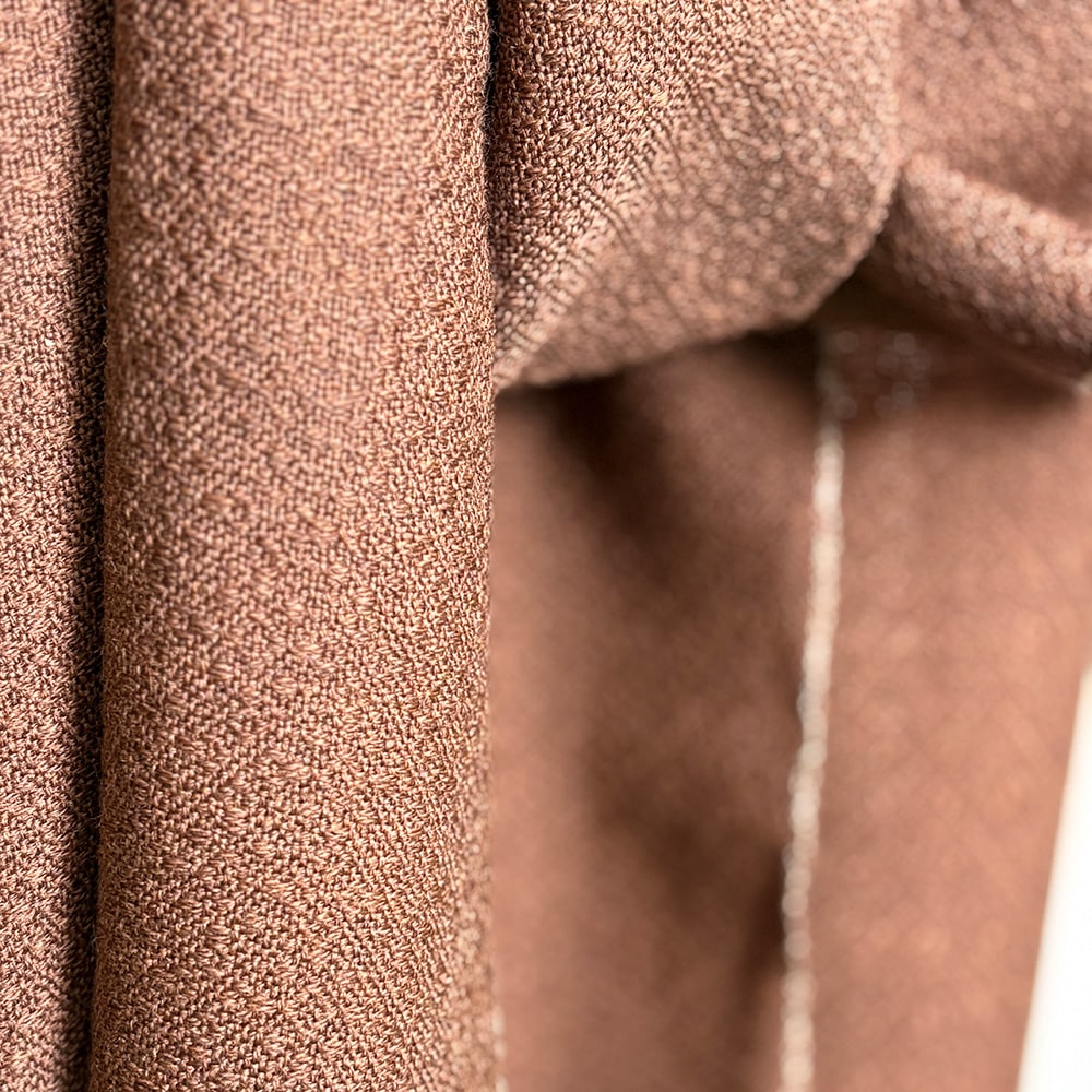 Ekslusivt håndvævet brunt tørklæde i merinould. Det er vævet brunt i brun ti et smukt mønster med lyse kanter der giver tørklædet karakter.